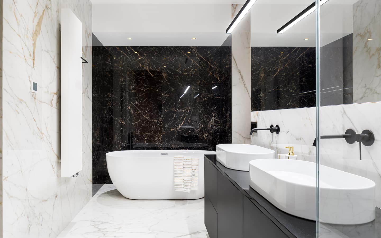 Bagno moderno di design con vasca ovale bianca, doppio lavabo, rivestimenti in marmo nero e bianco, specchi e luci a LED, stile elegante e contemporaneo