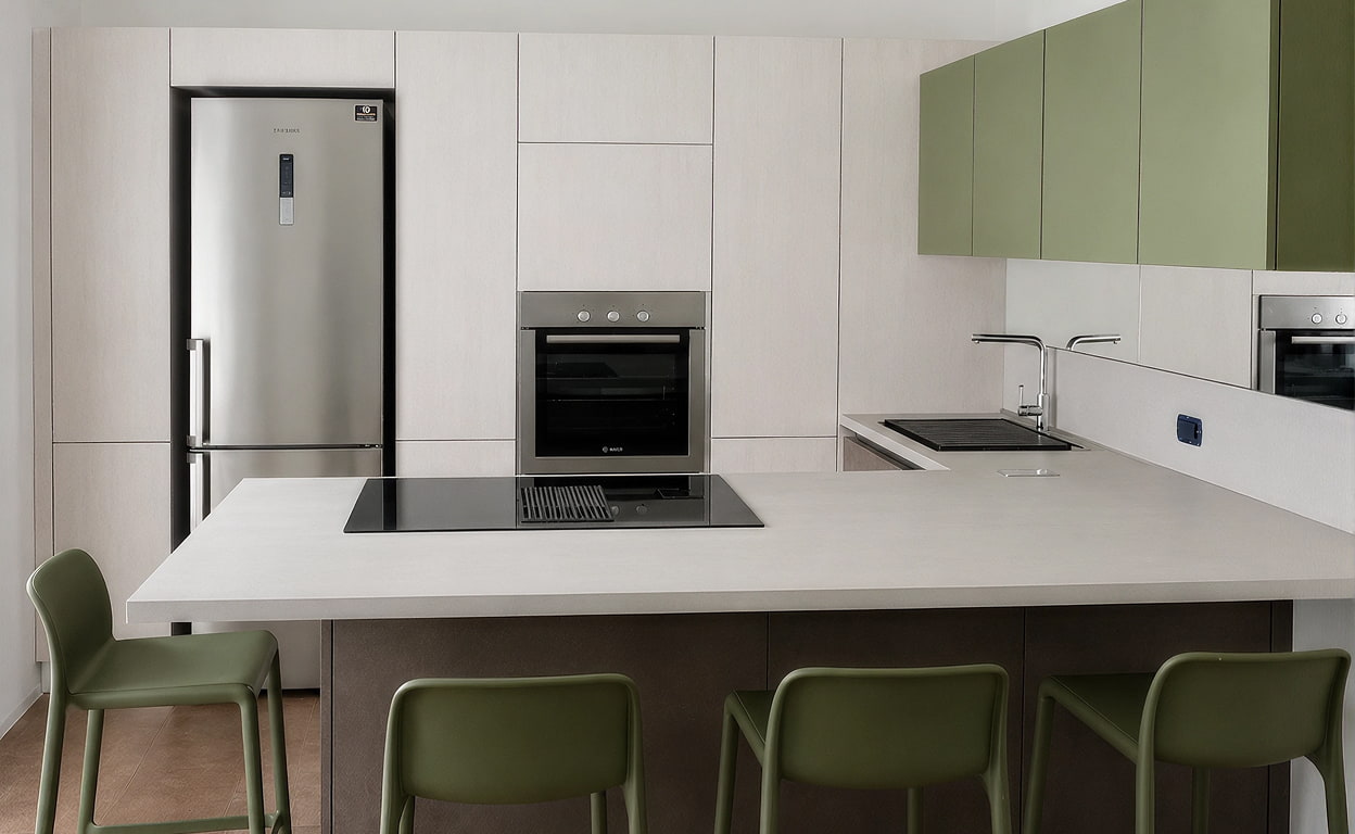 Cucina moderna con piano bianco, sedie verdi, pensili in verde e bianco, forno e piano cottura in un ambiente open space luminoso