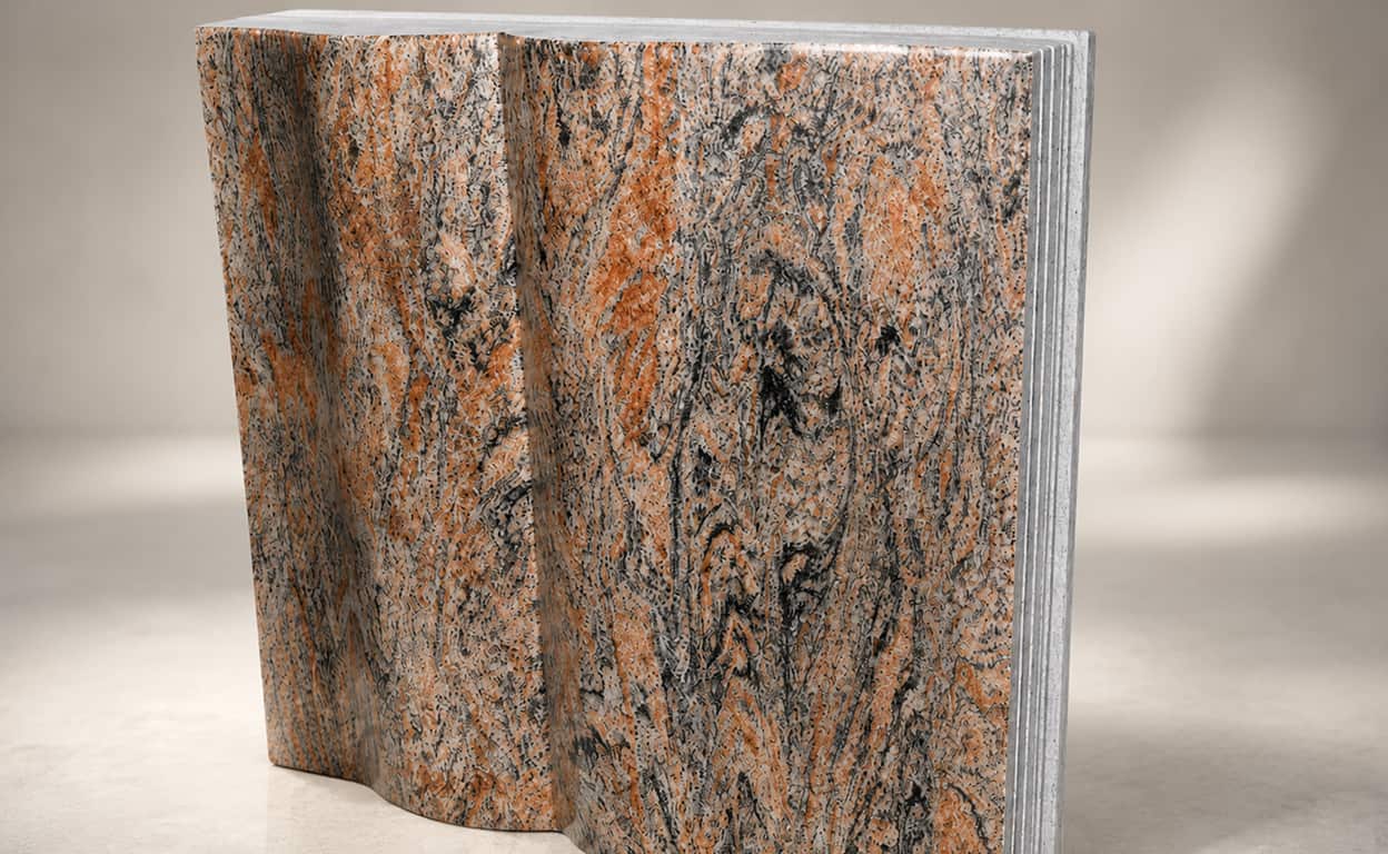 Campione di roccia granitica con venature arancioni e striature scure, tagliata e lucidatura parziale, su sfondo chiaro per analisi mineralogica