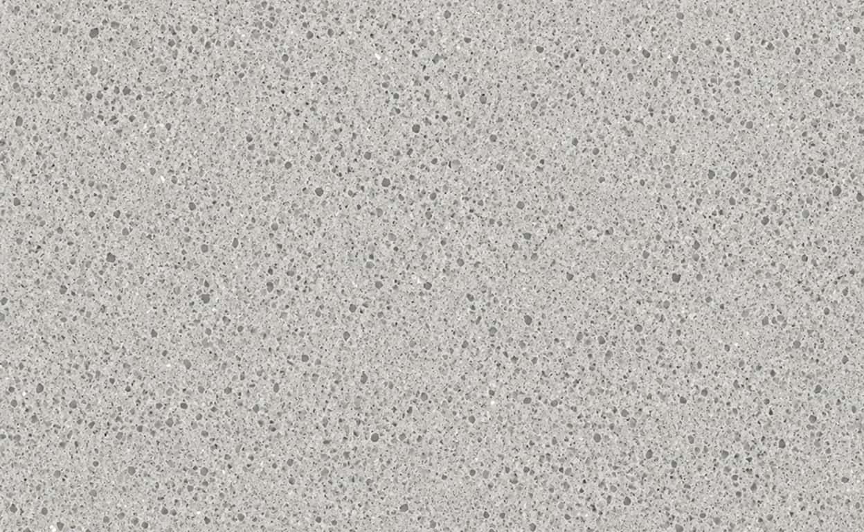 Superficie in pietra o cemento grigio chiaro con texture finemente granulosa e puntinata, vista ravvicinata, ideale per descrizioni di materiali e finiture