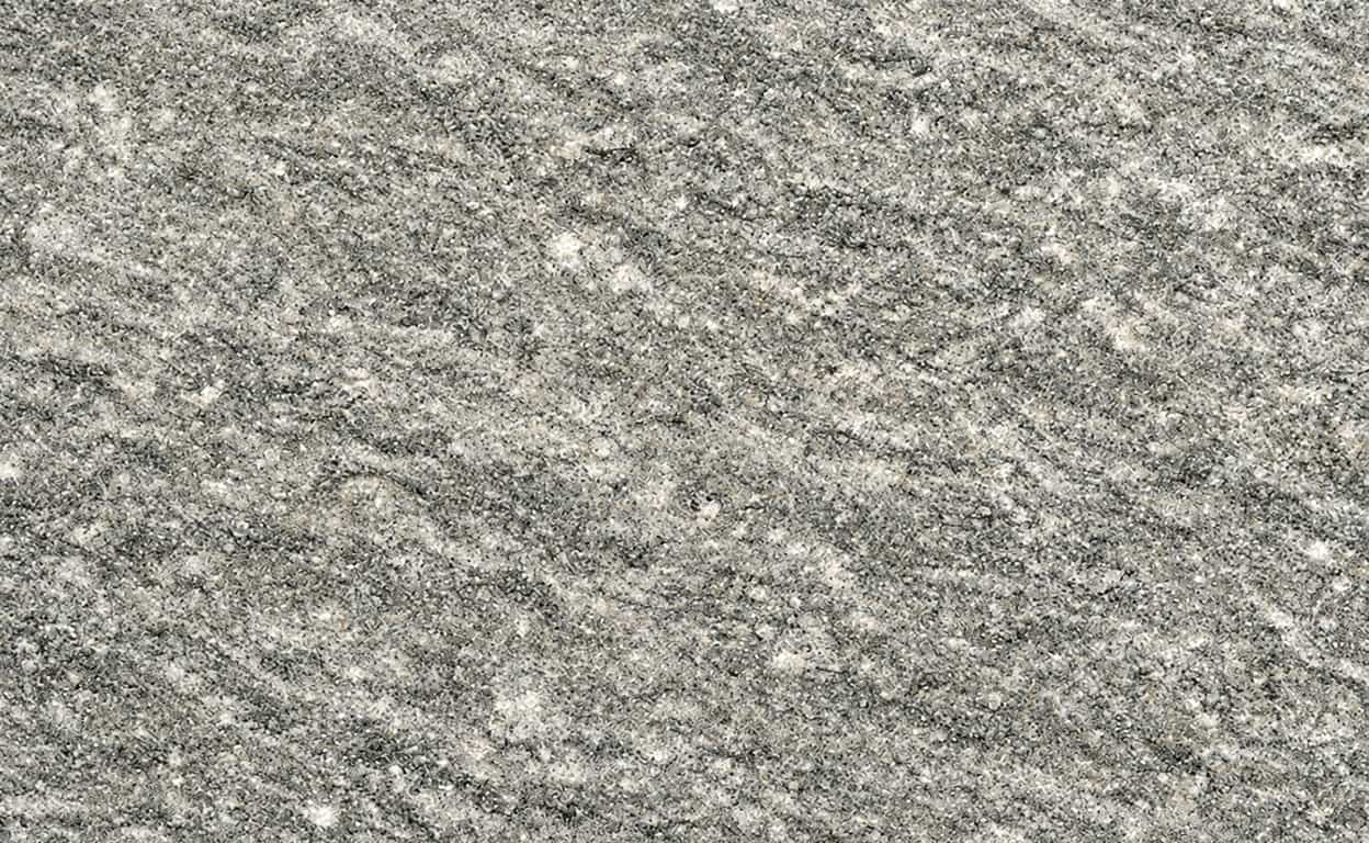 Texture dettagliata di granito grigio antracite con venature e granelli chiari e scuri, ideale per descrivere una superficie pietra naturale per rivestimenti